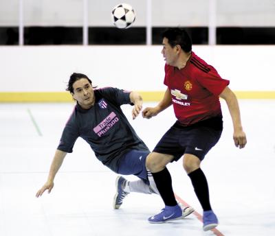 Eddy Sacaquirin, right, of Liga del Milagro headed a ball while Hugo Villacis of the East Hampton Soccer Stars applied defensive pressure in recent over-37 league action at the Sportime Arena in Amagansett.