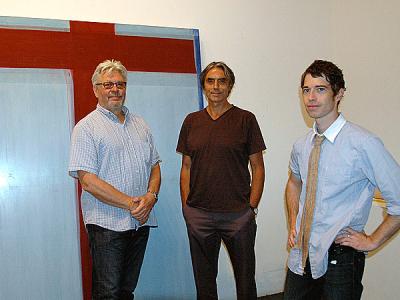Dan Rizzie, left, with Tad Wiley and Ross Watts in front of Mr. Wiley’s painting during the installation of “Artists Choose Artists” on Aug. 18