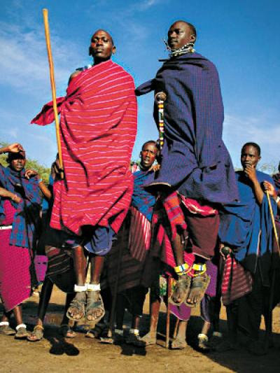 Young Masai men perform a traditional warrior dance. Kenny Mann’s earliest years were spent on her father’s cattle ranch on Masai land at the Athi River in Kenya.