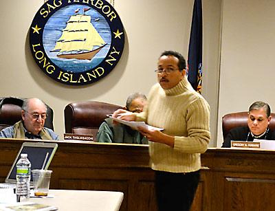 Michael Butler distributed photos to the village board, describing how the proposed Harbor Heights application would affect his neighboring property.