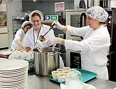 Debra Kulp, center, and Dee Hallock ladled out cups of soup in the kitchen at the East Hampton Town Senior Citizens Center last month. Behind them was Paula Bahmondes.