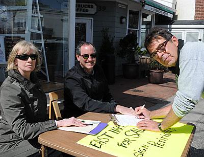 Pamela Bickett and Zachary Cohen, who narrowly lost a bid for town supervisor in November, collected signatures on Monday to force the town board to put a contested sale of public property to a townwide vote. Greg Turpan got ready to sign.