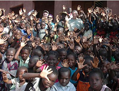 Fred Doss, John Gicking, and Shirin Kerman, rear, at a buildOn school site in Mali in 2006, surrounded by children who had never been to school in a proper building before.