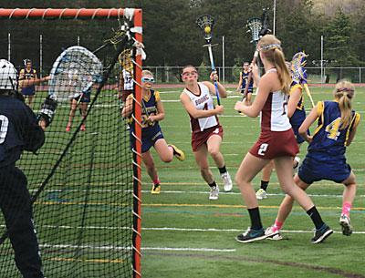 Maggie Pizzo, driving in on the North Fork team’s cage, led East Hampton’s scoring with three goals.