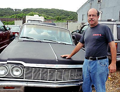 Tom Ferreira, outside his house on Navy Road in July of 2010, says the town illegally removed vehicles from his property, added the $19,700 hauling cost to his taxes, then placed a lien on his property when he couldn’t pay.