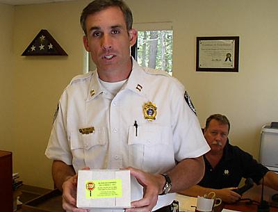 Capt. Michael Sarlo, of the East Hampton Town police, with Chief Edward Ecker Jr., rear, displayed a blood test kit of the type used on driving-while-intoxicated suspects after they are arrested.