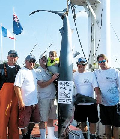 The crew of the P Pod posed with the 237-pound blue shark that took first place in the blue shark division of the Star Island Yacht Club’s shark tournament over the weekend.