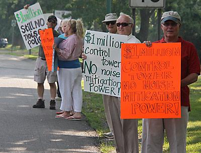 Before last Thursday’s East Hampton Town Board meeting, members of the Quiet Skies Coalition, angry about a new control tower at East Hampton Airport, stood outside Town Hall with signs decrying the tower and Councilman Dominick Stanzione, who oversees airport matters for the town board.