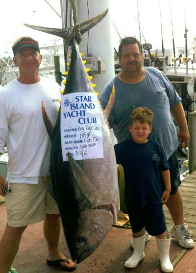 Chris Yates, left, caught this 185-pound (dressed weight) big-eye tuna from Capt. Peter Brancaleone’s Fish On boat on Sunday with the help of mate Peter Brancaleone Jr. The tuna was weighed in at the Star Island Yacht Club.