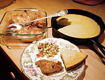 Skillet cornbread, Vietnamese chicken, and fresh corn salad on a dainty plate is one way of “roughing it” in a house devoid of kitchen supplies.