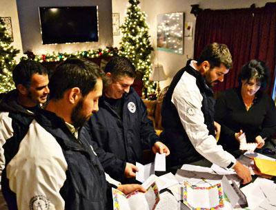 Coach Rich Brierley, far left, and players Nicholas Lawler, Ryan Borowsky, and Nick Finazzo stopped by the home of Melissa Ann Mitchell, at right, to pick up letters of support for residents of the Rockaways.