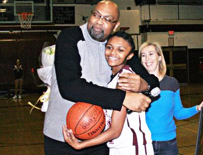 With her sister, Tiffany, looking on, Kaelyn Ward was embraced on the occasion of her 1,000th point by her coach, Howard Wood.