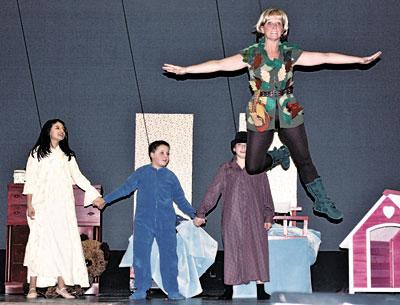 The Darling children, from left, Paula Guerra, Colin Freedman, and Dillon Andrada, watched Peter Pan, played by Jayne Freedman, take flight.