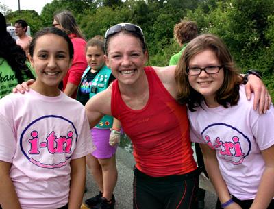 The women’s winner, Ali Crum, posed after crossing the line with two  I-Tri volunteers, Maliaq Guebli and Sarah Havens.