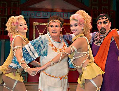 Peter Scolari, at left, barely manages to reject the charms of the Geminae Twins, Shiloh Goodin and Phoebe Pearl, as the buyer and seller of courtesans, Laurent Giroux, looks on.