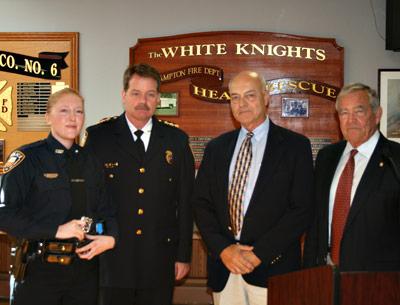 Jennifer Dunn, left, has joined the East Hampton Village Police Department as an officer after eight years as a dispatcher. She attended Friday’s village board meeting with, left to right, Chief Gerard Larsen Jr., Richard Lawler, a village board member, and Mayor Paul F. Rickenbach Jr.