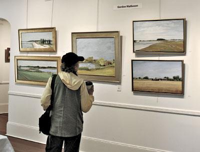 A visitor contemplated a painting at Plein Air Peconic’s exhibition last weekend at Ashawagh Hall in Springs.