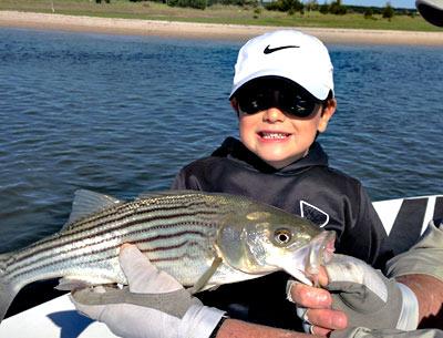 Andrew Mark, 7, landed his first fish — a striped bass — on a spinning road he had just learned to use.