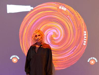 Nina Yankowitz is illuminated by her Vortex Paint Game, one of two interactive games in her Guild Hall installation, “Criss-Crossing the Divine,” that invite viewers to engage in a dialogue with sacred religious texts.