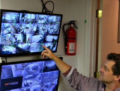 Bruce Damark, a third-generation owner of Damark’s, with monitors for the new surveillance system he put in place to protect the deli.