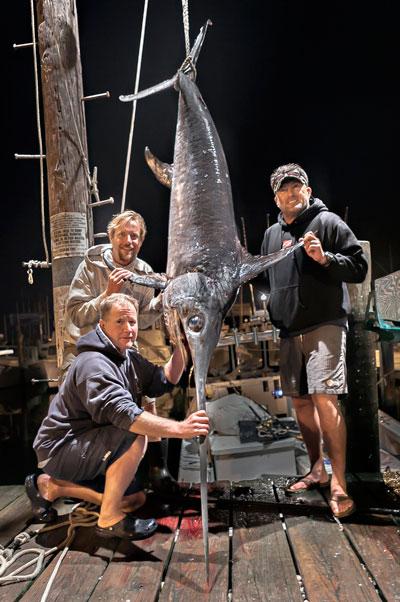 Pat Wetzel, kneeling, Chris Miller, and Mike Tierney caught this 256-pound swordfish aboard the Sea Spearit in the Fishtails section of Block Canyon on Monday morning.