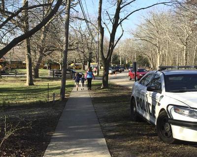 A police officer monitored traffic in front of the Springs School yesterday. The Springs School Board wants to increase parking and improve traffic flow.