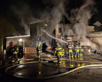 Firefighters worked to control a blaze at the rear of the J. Crew store on Main Street in East Hampton Village on Friday that apparently began when a refrigeration unit at Rowdy Hall restaurant next door malfunctioned.