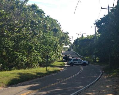 The driver of a Jeep that rolled over after crossing the Cranberry Hole Road bridge in Amagansett on Saturday afternoon was badly injured and later charged with unlicensed driving, driving while intoxicated, and drug possession.