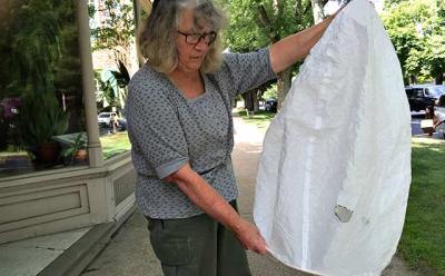 Joan Palumbo, a Montauk resident, holding a Chinese lantern she discovered last week on her roof. It shows an apple-size burn hole.