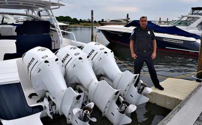 Robert Bori, the Sag Harbor Village harbormaster, straddled a boat at a village dock and an EZ Dock. The boat’s owner got permission for the dock extension because its outboard motors made it too hard to easily reach from the dock.