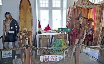 A simulated beach scene is the backdrop for a display of vintage surfboards and memorabilia at the Oceans Institute and Surf Museum at the Montauk Lighthouse.