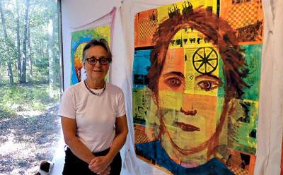 Christina Schlesinger was framed by the view of the woods behind her Springs studio while she showed her new mixed-media portraits.