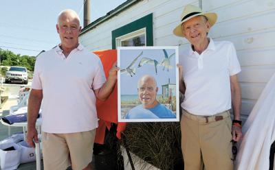 Perry Duryea III received a painting of himself from Paul Davis, right, at a Fighting Chance lunch in Montauk on Friday.