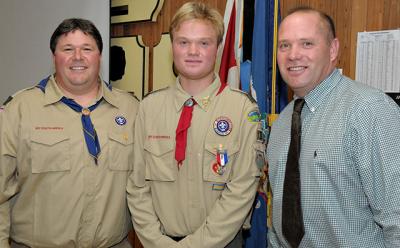 Brenden Snow, center, received his Eagle Scout Award during a ceremony on Sunday attended by many well-wishers including Vincent Franzone, left, who pinned the badge on him, and his father, Scott Snow.