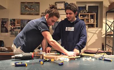 Yanni Giannakopoulos, left, and Malik Basnight, right, have taken on complicated woodworking projects at the Ross School. Yanni is replicating a famous guitar, Malik is building four artistic chairs, and the two friends have been helping each other along the way.