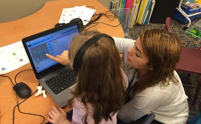 Kembly Berrocal, right, a teaching assistant at the Wainscott School, helped a young student with a coding activity during a technology lesson.