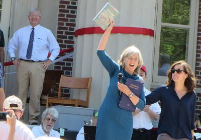 Catherine Creedon, the director of the John Jermain Memorial Library, triumphantly held up the book “Sag Harbor: The Story of an American Beauty” on its way on Saturday from the library’s temporary home on West Water Street to its permanent location on Main Street.