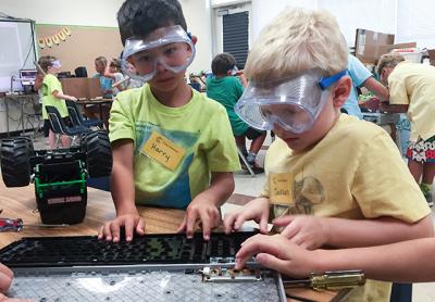 Harry Thomas, left, and Jackson Rogers took apart a broken computer keyboard to see what was inside during an activity called Maker Studio at Camp Invention.