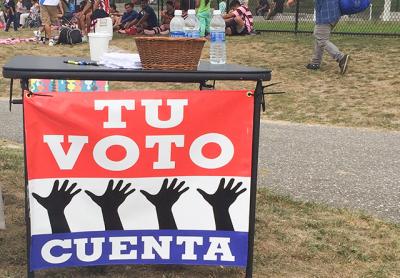 Volunteers with the Organizacion Latino-Americana of Long Island displayed a sign reading “your vote counts” in Spanish on Sunday during a voter recruitment drive at an athletic event.