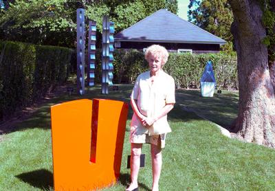 Like much of Carol Ross’s aluminum sculpture, “Gorge,” seen here with the artist in Guild Hall’s sculpture garden, is an abstract, almost Minimalist response to nature.