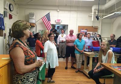 Community members packed the robotics lab during a tour of the Bridgehampton School last week, as Judiann Carmack-Fayyaz, the robotics teacher, left, explained that the basement classroom is difficult to work in, lacks a true emergency exit, and is not handicapped-accessible.