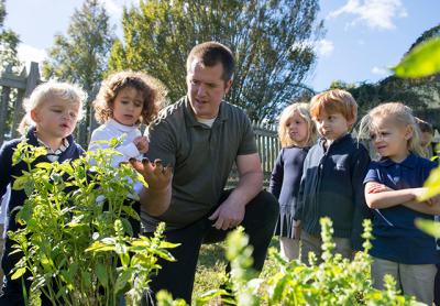 Bryan Smith, center, a Ross School science teacher, often leads lessons outdoors on the Lower School campus, which has recently been certified as a wildlife habitat by the National Wildlife Federation.