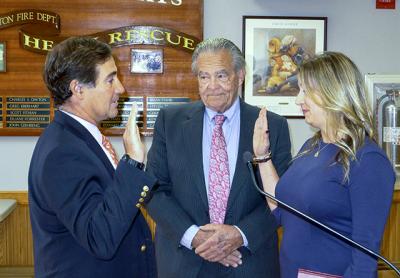 Philip O’Connell, left, was sworn in as the newest member of the East Hampton Village Board by Rebecca Molinaro, the village administrator, as Mayor Paul F. Rickenbach Jr. looked on.