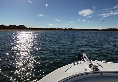 Several small boats congregated in a cove west of Orient Point, where striped bass were pressing their prey against the beach.