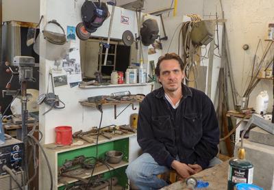 Paul Pavia surrounded by the many tools of his trade in his Springs studio. Below, “Morat Coil,” 2016, bronze, wood, and  marble