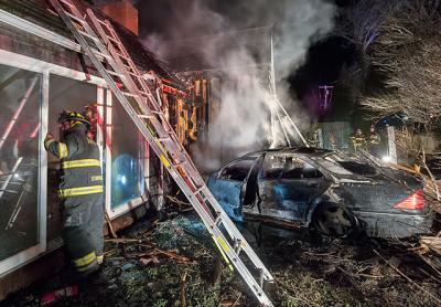 A burned-out shell was all that remained of the Mercedes that crashed through a fence before slamming into a house on Hayground Road in Water Mill early Sunday morning. The house was badly damaged by fire.