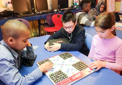 How many words can you make from 25 random tiles? Mikhail Feaster, left, Carlos Carmona, center, and Jasmin DelGiorno ponder the challenge at the Bridgehampton Child Care and Recreation Center.