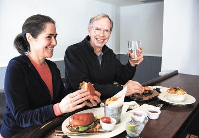 Cynthia and John Kaufmann sampled the pulled pork slider and veggie burger at the Springs Tavern bar, which opened April 1.