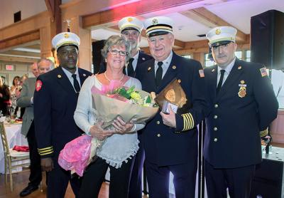 The East Hampton Fire Department chiefs presented Kenny Brown, an ex-chief and active member, with a plaque for his 55 years of service. They also gave his wife, Linda Brown, a bouquet. The chiefs, from left, are Jamalia Hayes, the second assistant chief, Chief Ken Wessberg, and Gerry Turza, the first assistant chief.