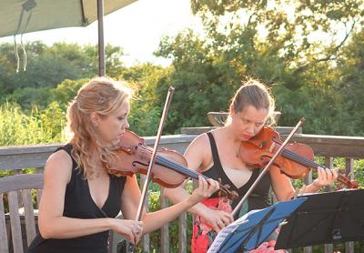 Joanna Maurer and Annaliesa Place performing at an outdoor concert last year